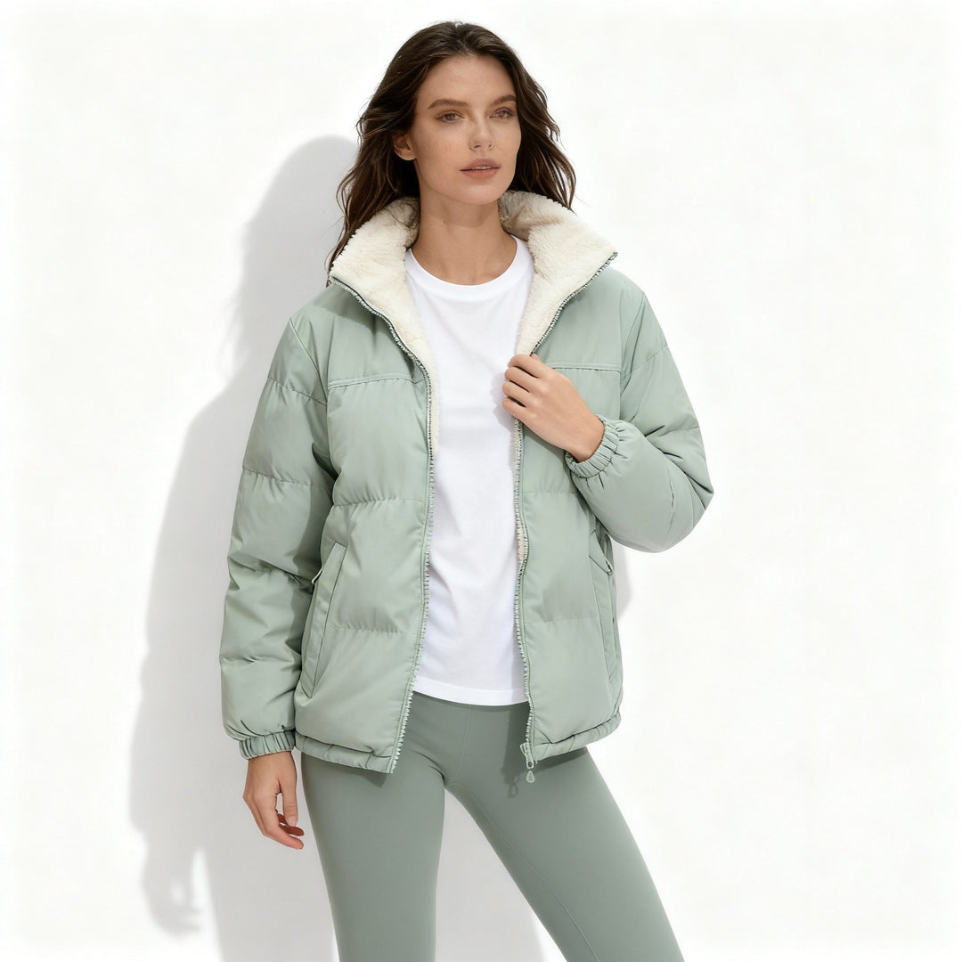 Beige quiltad damjacka med ståkrage sedd bakifrån, visar den varma designen.
