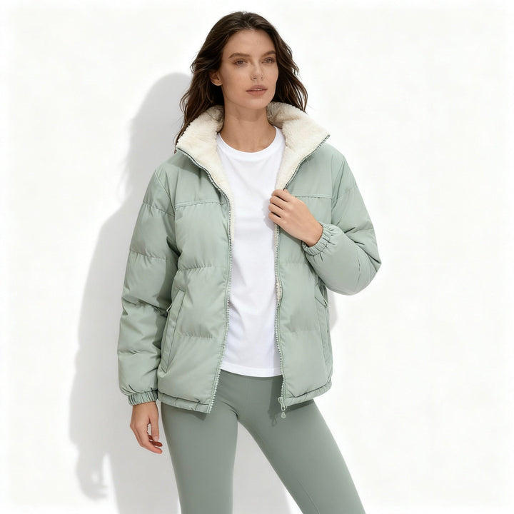 Beige quiltad damjacka med ståkrage sedd bakifrån, visar den varma designen.
