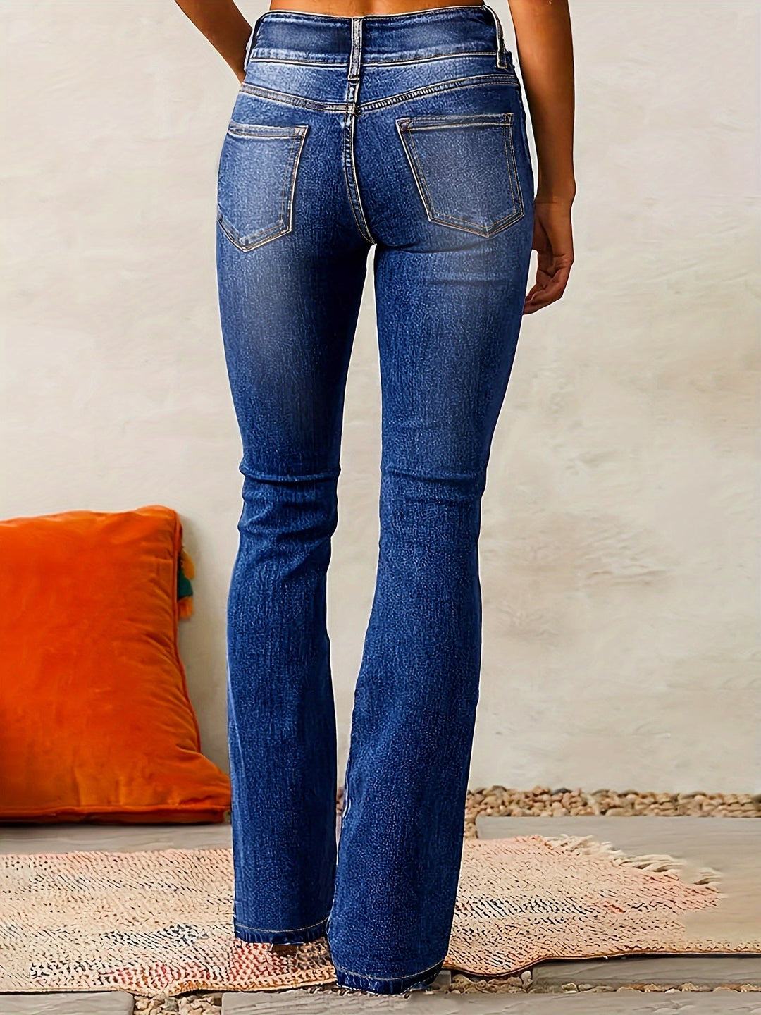 Närbild på tyget av utsvängda kvinnors jeans med hög midja, visar stretch och textur.