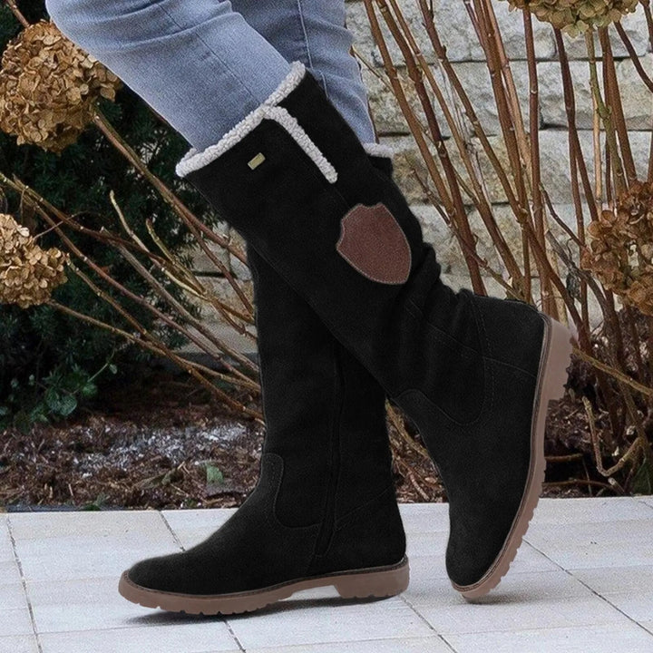 Närbild av dam vinterstövlar med beige foder och robust halkfri sula, idealiska för friluftsliv och kyla.
