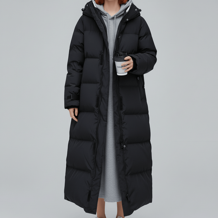 Varm vinterkappa för dam, lång och vadderad med huva. Abigail-modell, ett elegant ytterplagg för kyla.