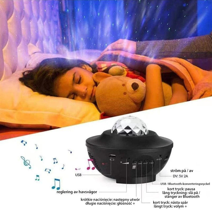 "LED nattlampa med färgprojektion och Bluetooth-högtalare, visar färgglada ljuseffekter i mörkt rum."