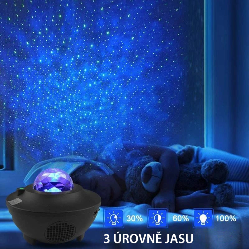 "LED nattlampa med färgprojektion och Bluetooth-högtalare, visar färgglada ljuseffekter i mörkt rum."