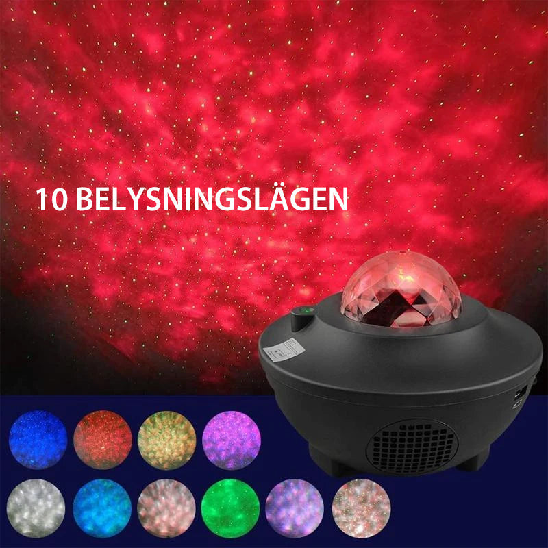 "LED nattlampa med färgprojektion och Bluetooth-högtalare, visar färgglada ljuseffekter i mörkt rum."