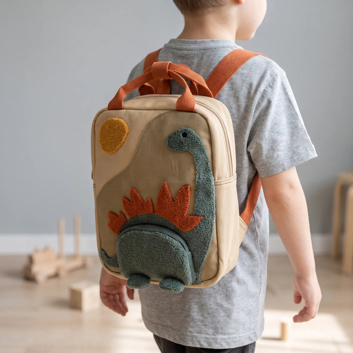 Lekfull barnryggsäck med grönt dinosauriemönster, perfekt för förskolan och små äventyrare.