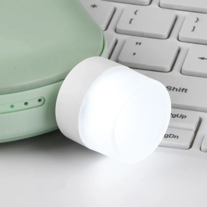 Liten USB LED nattlampa med ögonskydd, kompakt och stilren, avger mjukt vitt ljus, perfekt för sovrum och resor.