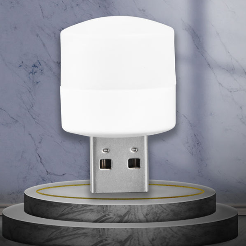 Liten USB LED nattlampa med ögonskydd, kompakt och stilren, avger mjukt vitt ljus, perfekt för sovrum och resor.