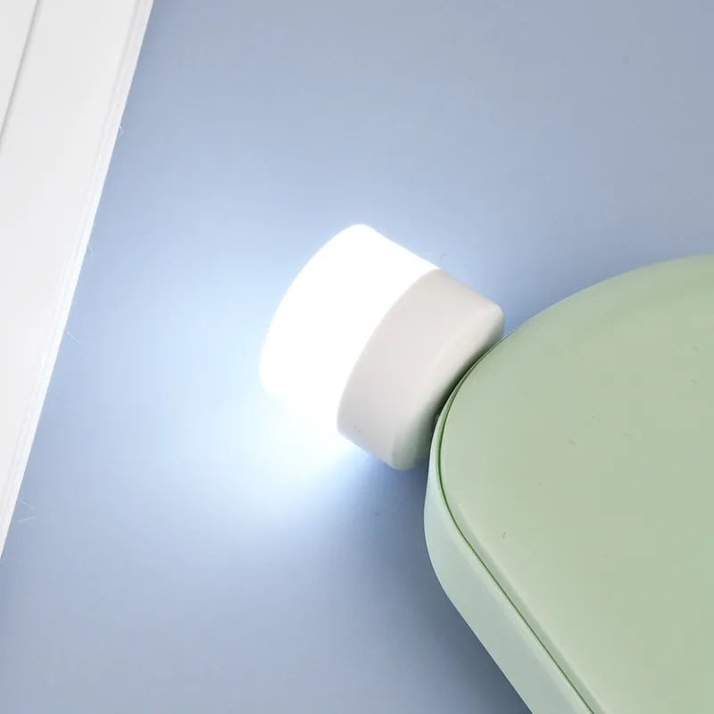 Liten USB LED nattlampa med ögonskydd, kompakt och stilren, avger mjukt vitt ljus, perfekt för sovrum och resor.
