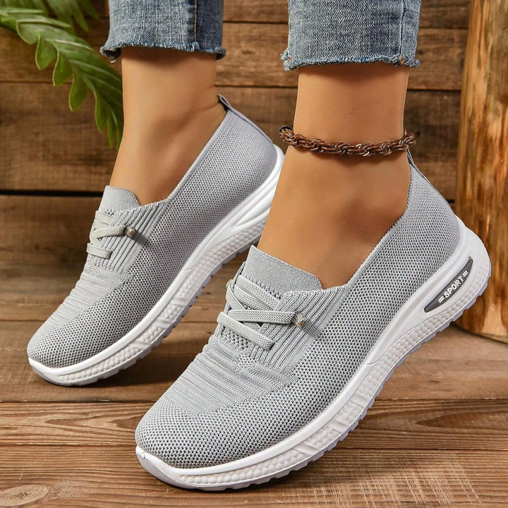 Närbild på ljusgrå slip-on damsneaker, visar bred tåbox och bekväm ovandel. Optimal promenadsko.