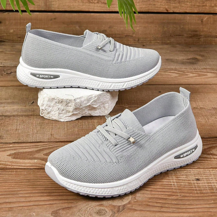 Sportiga ljusgrå slip-on damsneakers med breda tår. Bekväma promenadskor för en aktiv livsstil.