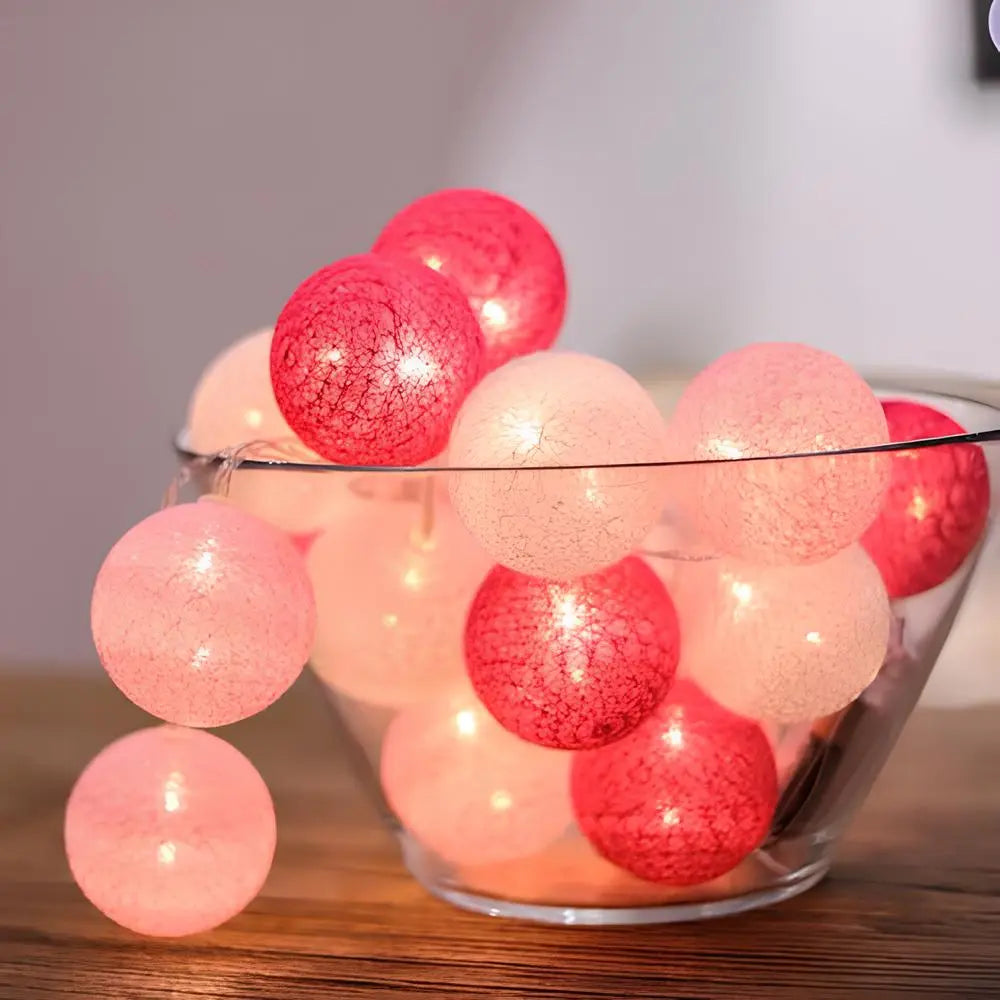 Trendig bomullsbollsljusslinga som en del av modern heminredning, ger stämningsfull belysning.