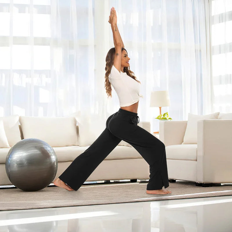 "Lösa yogabyxor med vida ben för kvinnor i smörigt mjukt tyg, elastiskt midjeband och djupa sidfickor."