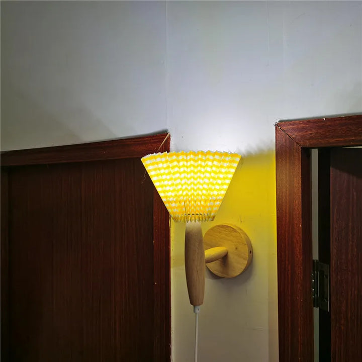 Vacker Lyren vägglampa i modern nordisk stil. Trädetaljer och plisserad textilskärm för en tidlös look.