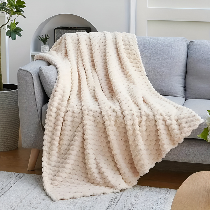 Snygg filt med geometrisk design, en lyxig hemtextil som ger värme och stil.