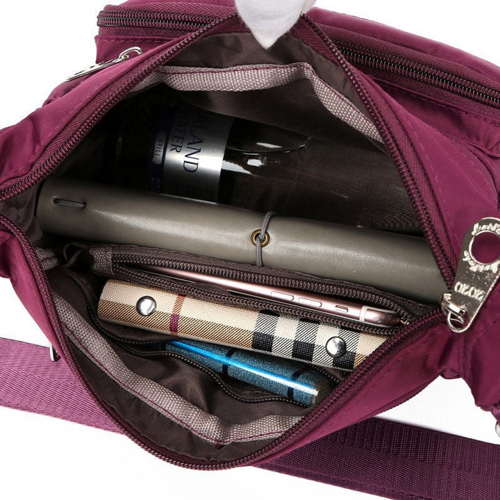 Mångsidig och slitstark axelremsväska i nylon för kvinnor, med justerbar rem och flera fickor, perfekt för vardag och resor.