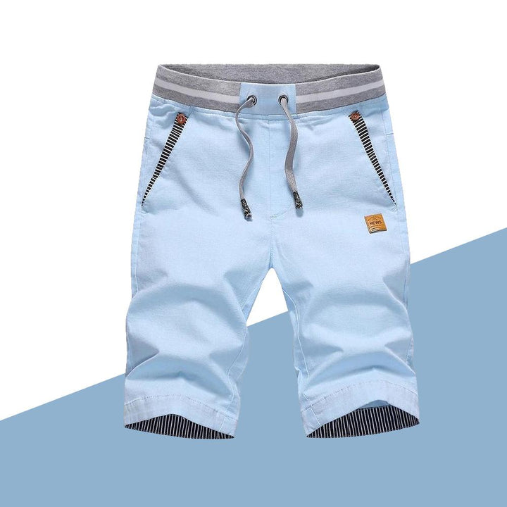 "Mäns casual shorts med elastisk midja i bomull, randig fickdetalj och bakfickor, visad framifrån i ljusgrå nyans."