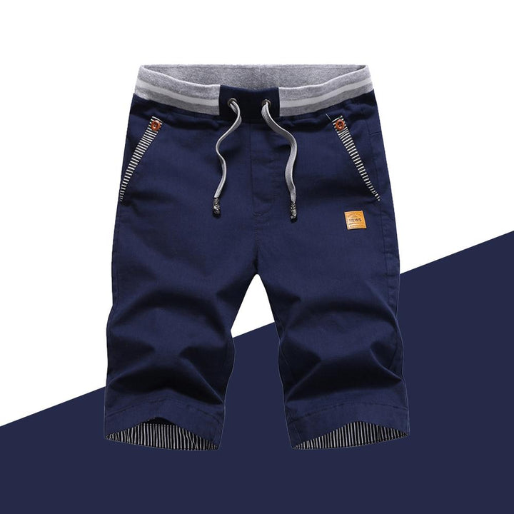 "Mäns casual shorts med elastisk midja i bomull, randig fickdetalj och bakfickor, visad framifrån i ljusgrå nyans."