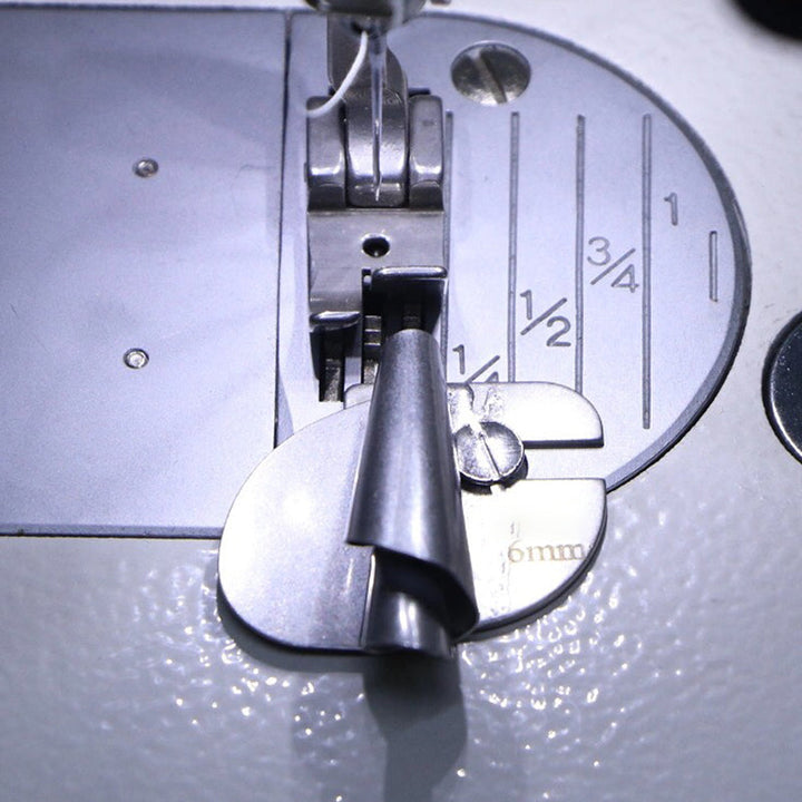 "Metallisk rullad sömspressarfot för sömnad, visad med tyg, för exakta fållar. Perfekt för både tunna och tjockare tyger."