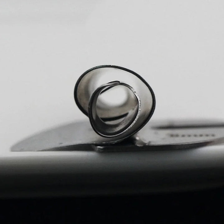 "Metallisk rullad sömspressarfot för sömnad, visad med tyg, för exakta fållar. Perfekt för både tunna och tjockare tyger."