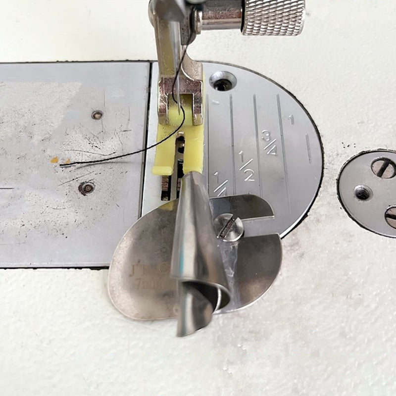 "Metallisk rullad sömspressarfot för sömnad, visad med tyg, för exakta fållar. Perfekt för både tunna och tjockare tyger."