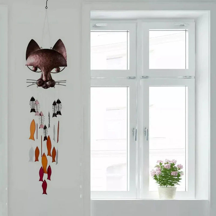 "Metallisk vindspel med katt och fiskdesign, detaljrikt konstverk för trädgård eller terrass. Vattentålig och elegant."