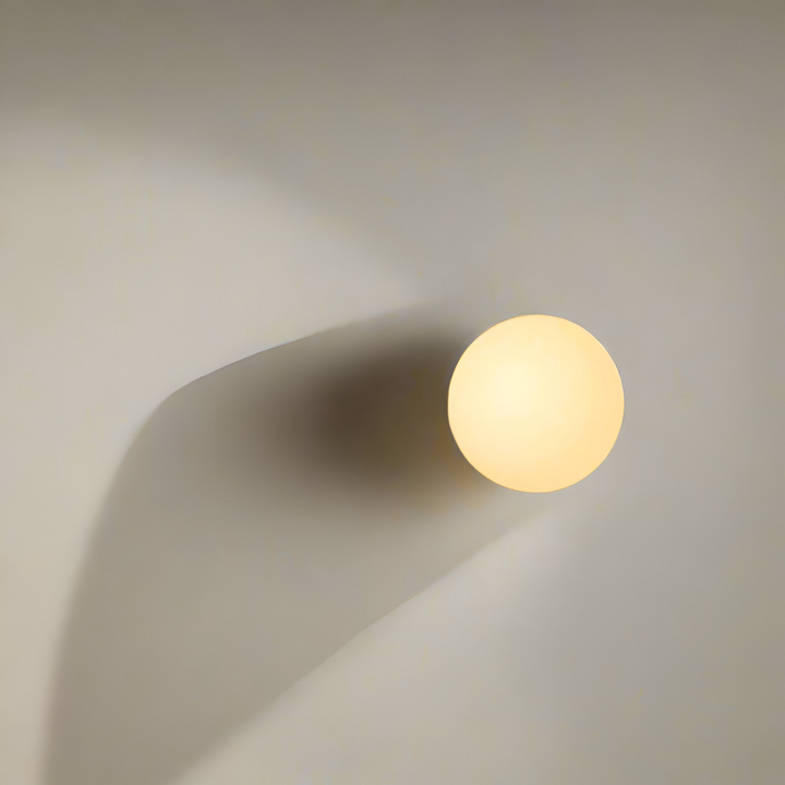 Vägglampa i minimalistisk design, rund glasform med effektiv LED-belysning.