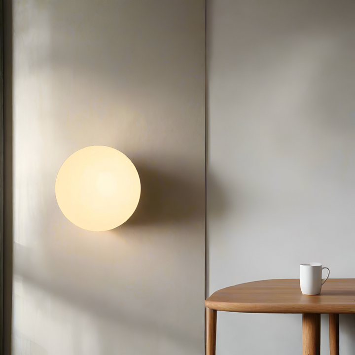 Elegant rund LED-vägglampa i glas, perfekt för stilren heminredning.