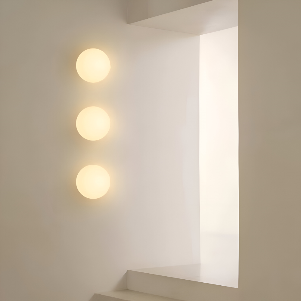 Designad glasvägglampa, rund och minimalistisk, för inomhusbruk.