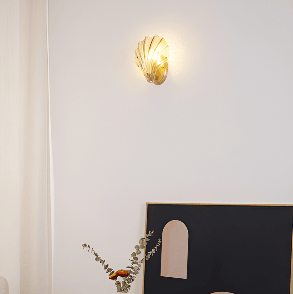 Enkel vägglampa med klart glasskal och mässingsfäste. Modern belysning för hemmet.