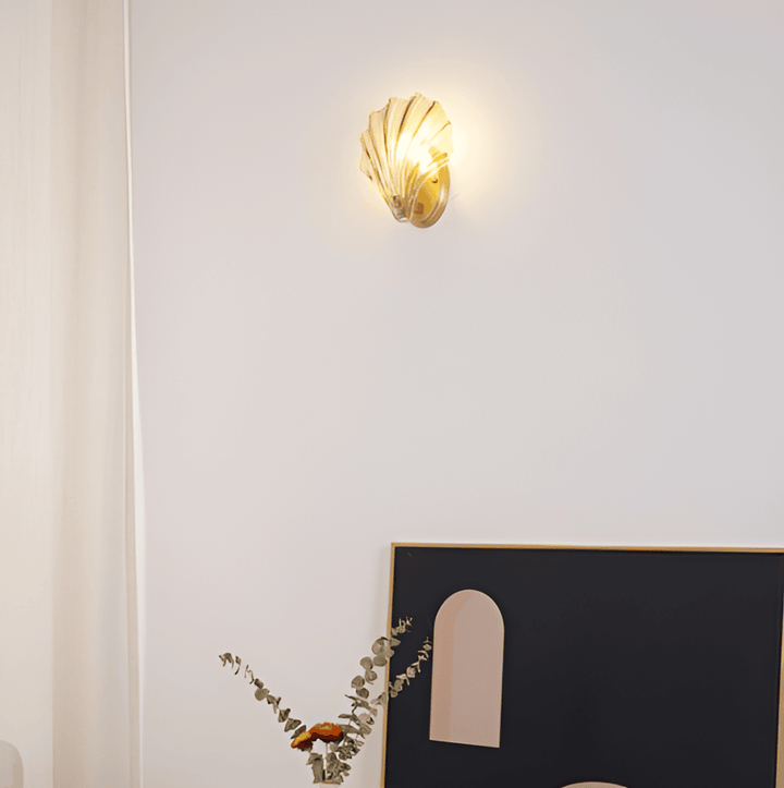 Enkel vägglampa med klart glasskal och mässingsfäste. Modern belysning för hemmet.