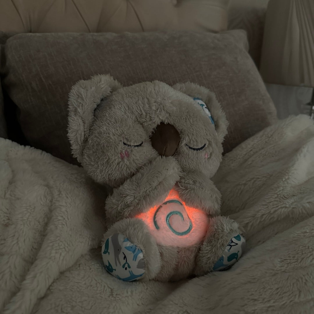 Vit plyschkoala andas rytmiskt. Fungerar som insomningshjälp och lugnande nattlampa för barn.