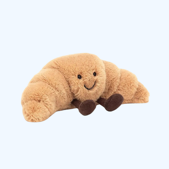 Rolig skrattande croissant som mjukt plyschdjur, idealisk som kramkamrat för barn och bebisar.