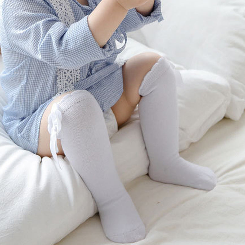 "Mjuka knähöga småbarnsstrumpor med söt rosett, idealiska för flickor. Perfekta för kyliga dagar och stilfulla outfits."