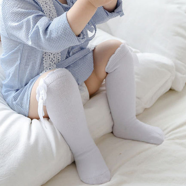 "Mjuka knähöga småbarnsstrumpor med söt rosett, idealiska för flickor. Perfekta för kyliga dagar och stilfulla outfits."