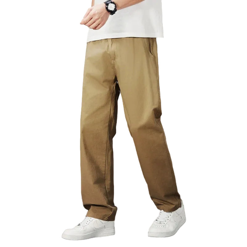 Modell bär beiga herr casual byxor med rak passform, idealiska för vardagsbruk och komfort.