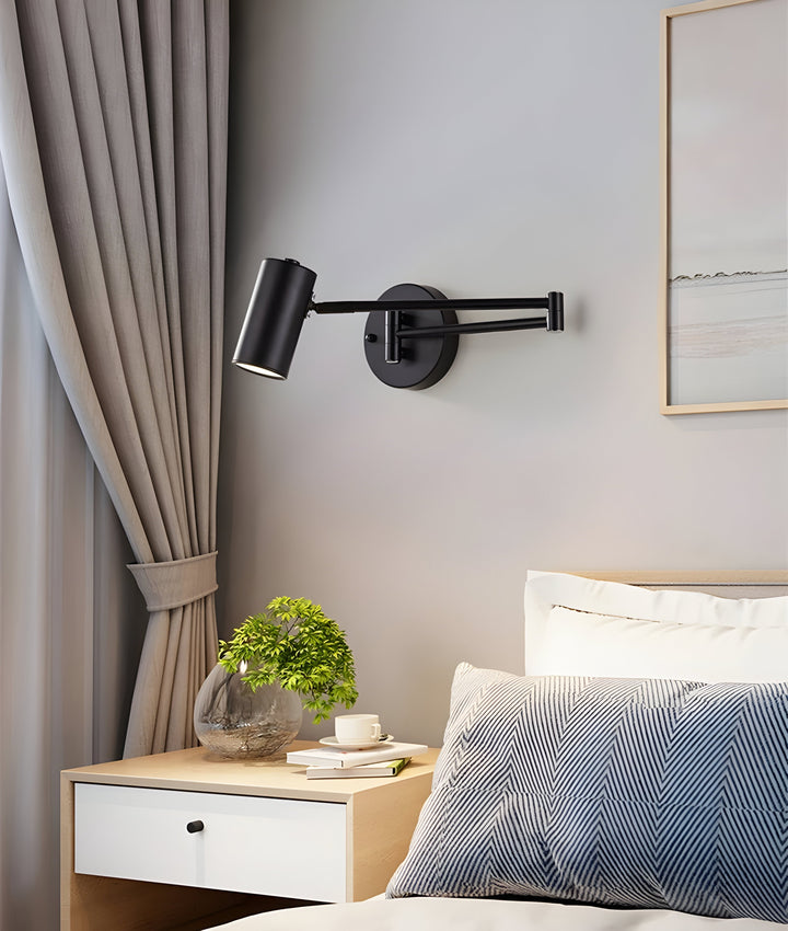 Detaljbild på den justerbara armen av en modern vägglampa i svart och guld. Flexibel designlampa.