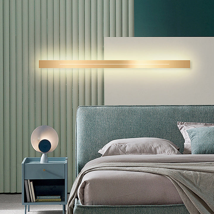 Elegant guld LED-vägglampa, modern design, skapar mysig atmosfär i hemmet.