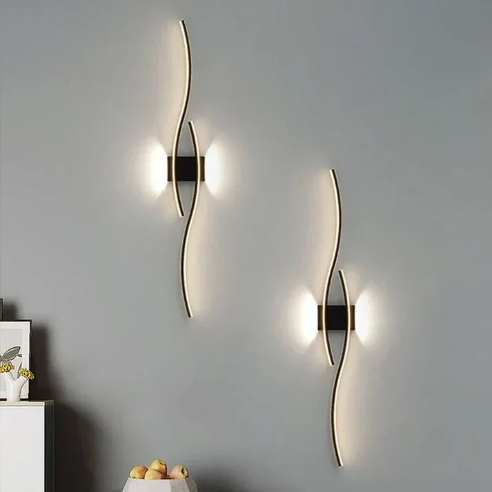 Modern LED-vägglampa med elegant vågdesign för stilfull vardagsrumsbelysning.
