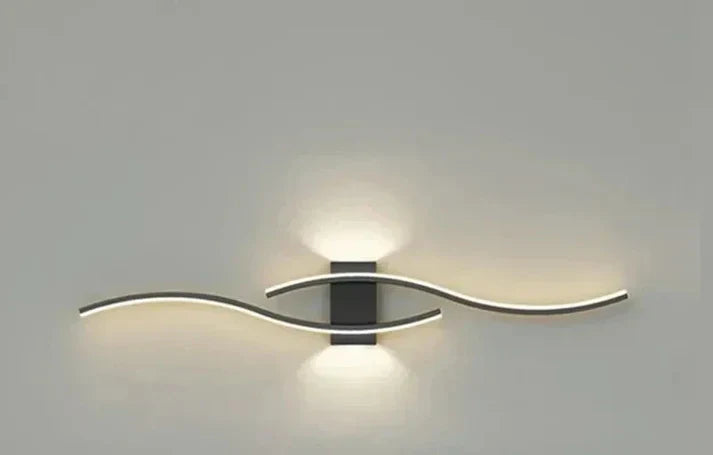 Stilfull vit LED-vägglampa med unik vågdesign, idealisk för modern inredning.