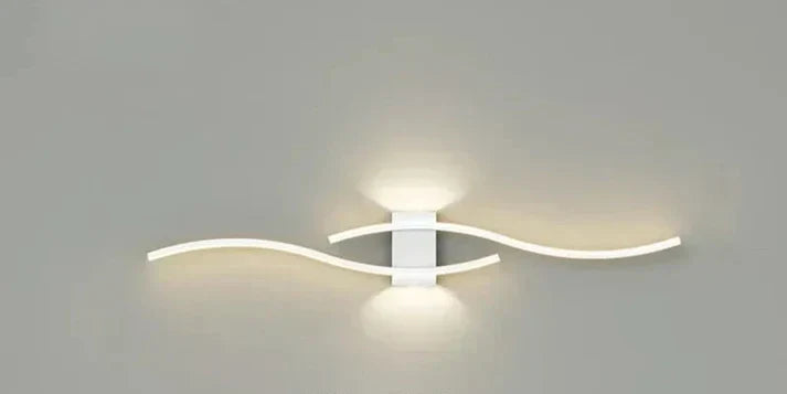 LED-vägglampa med skulptural vågform, ger mjuk och behaglig belysning i hallen.