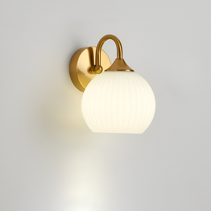 Kvällsbild av modern randig vägglampa, lyser upp vardagsrummet med varmt LED-sken.