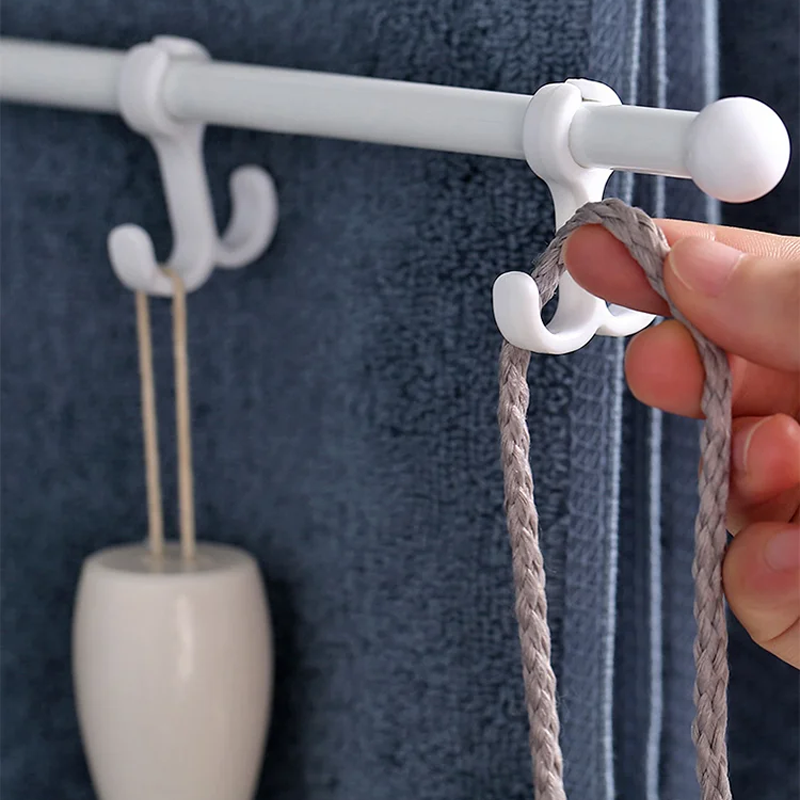 "Modern stansfri handdukstork med roterande armar i vit plast, enkel installation i badrum för torra handdukar."
