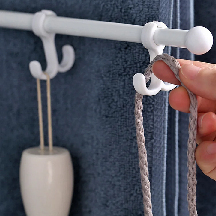 "Modern stansfri handdukstork med roterande armar i vit plast, enkel installation i badrum för torra handdukar."
