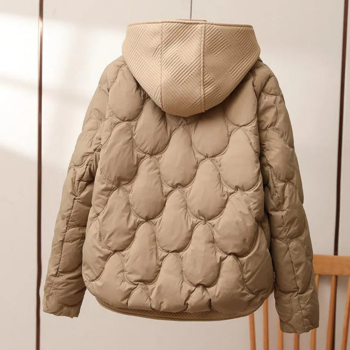 Trendig kvinnlig pufferjacka i mörkblått, designad för bekväm isolering på vintern.
