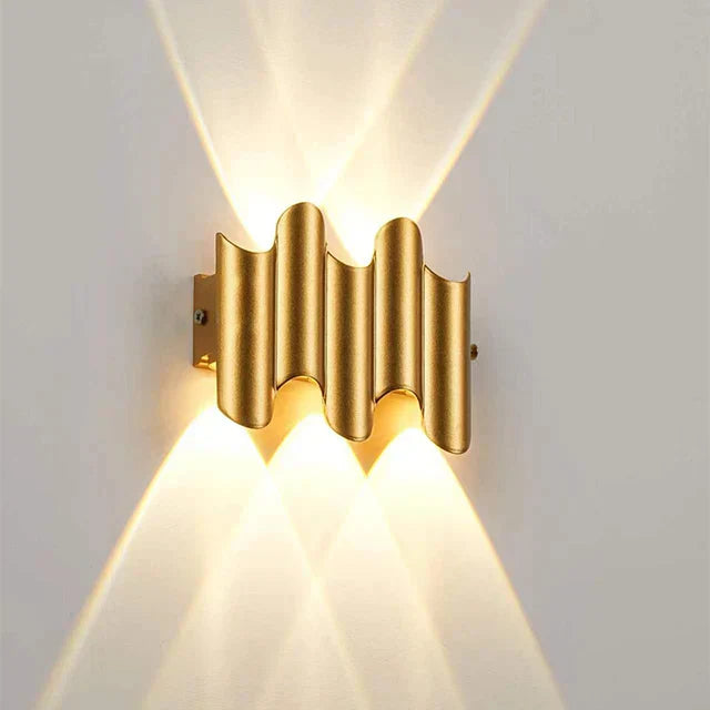 Modern LED vägglampa, svart och guld. Ger effektivt upp/ner-ljus, perfekt för korridor eller vardagsrum.