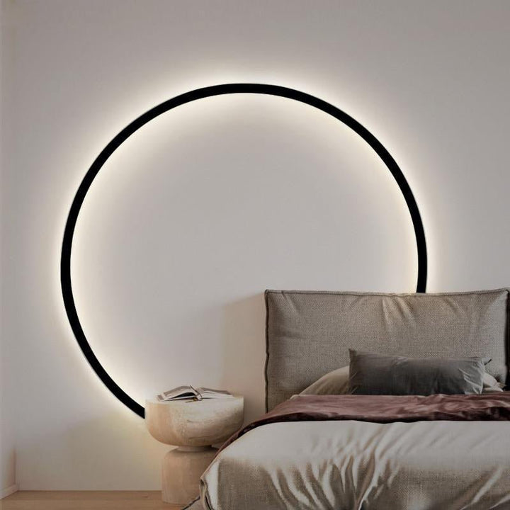 Svart rund vägglampa i modern design, skapar mysig atmosfär med LED-ljus.