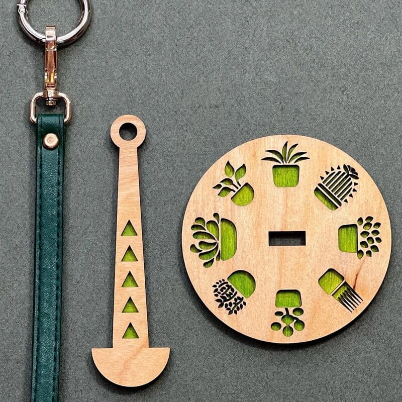 "Modern trähållare för garn i minimalistisk design, visar flera garnrullar i olika färger på en stabil träbas."