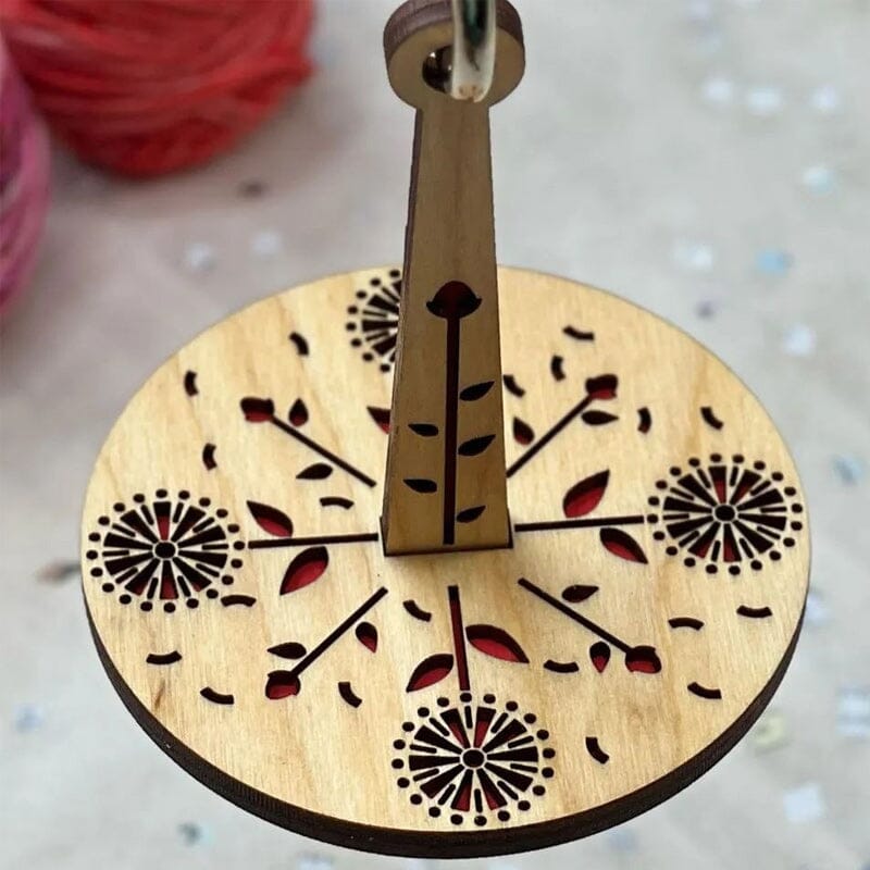 "Modern trähållare för garn i minimalistisk design, visar flera garnrullar i olika färger på en stabil träbas."