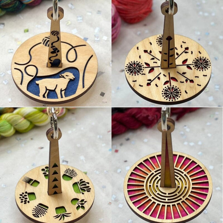 "Modern trähållare för garn i minimalistisk design, visar flera garnrullar i olika färger på en stabil träbas."