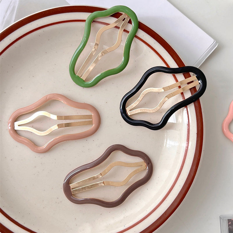 "Molnformade hårklämmor för kvinnor i olika färger, tillverkade i metall och plast, perfekt för stil och funktion."